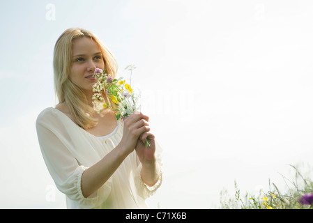 Junge Frau, die duftenden Bouquet von Wiesenblumen Stockfoto