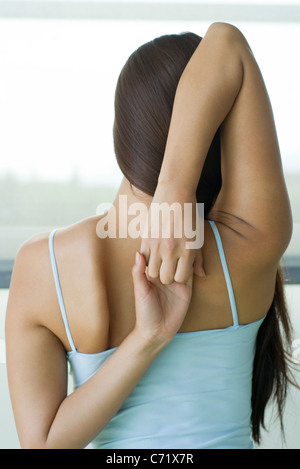 Frau tut Yoga-Kuh-Gesicht-Pose, Rückansicht Stockfoto