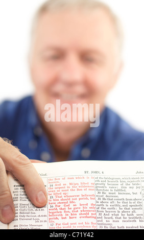 Senior Pastor zeigt ein wichtiges Versprechen der Schrift (denn also hat Gott die Welt, die er seinen eingeborenen Sohn geliebt) Stockfoto