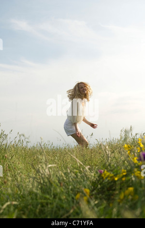 Junge Frau im Bereich der Wildblumen springen Stockfoto