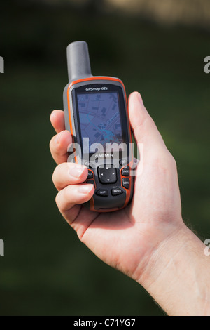 Mann, der einen GPS-Empfänger in der Hand hält. Stockfoto