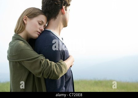 Junge Frau umarmt Freund Stockfoto