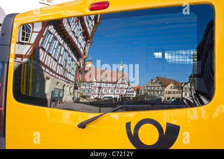 POST BUS, REFLEXION, MARKTPLATZ IN BAD URACH, SCHWÄBISCHE ALB, BADEN-WÜRTTEMBERG, DEUTSCHLAND Stockfoto