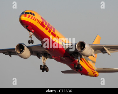 DHL Boeing 757-200F-Frachtflugzeug startet bei Sonnenuntergang. Nahaufnahme des Flugzeugs von vorn. Gewerblicher Luftfrachtverkehr. Internationaler Handel. Stockfoto