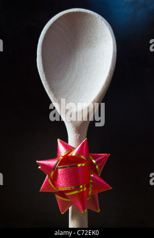 Einem Holzlöffel mit einer Rosette an den Stamm des Griffs befestigt. Stockfoto