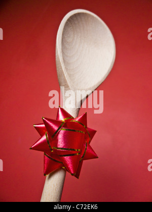 Einem Holzlöffel mit einer Rosette an den Stamm des Griffs befestigt. Stockfoto