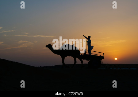 Mensch und Kamel Wagen Silhouette bei Sonnenuntergang Sam Dünen Desert National Park westlichen Rajasthan Indien Stockfoto