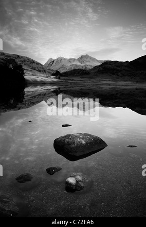 Schwarz / weiß Format Portraitbild von Langdale Pikes spiegelt sich in ruhigen Blea Tarn im englischen Lake District Stockfoto