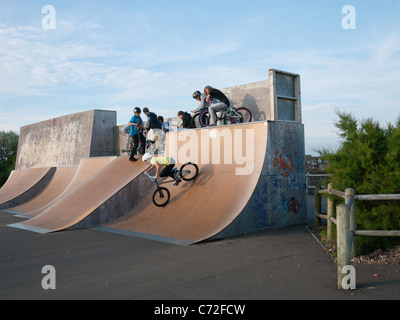 Junge Menschen auf Fahrrädern und Scoooters im Meer Skatepark in Eastbourne, East Sussex Stockfoto