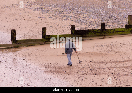 Ein Mann sucht den Strand von Cromer Norfolk mit Metall detecor Stockfoto