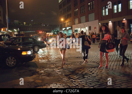 Fashionistas manövrieren die gepflasterten Straßen in ihrer Designer-Schuhe im angesagten Meatpacking District in New York Stockfoto