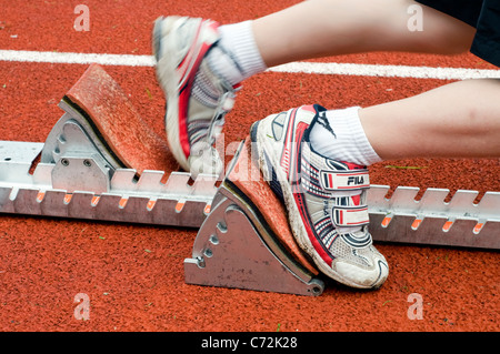 Ein Läufer platzen aus den Startblöcken in einem Sprintrennen Stockfoto