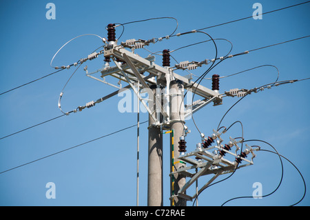 elektrische Pole und Hochspannungsleitungen mit Isolatoren Stockfoto