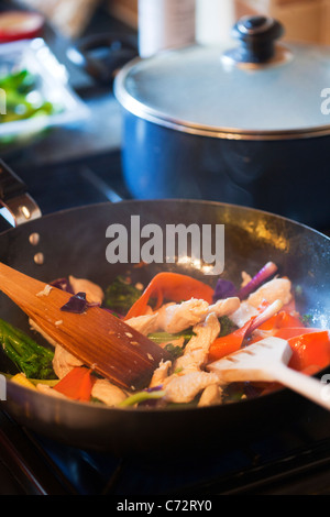 Chinesische Pfanne wird im traditionellen Wok mit Holzlöffeln, gekochtes Hühnerfleisch, Paprika, Zwiebeln Kochen Hongkong Stockfoto