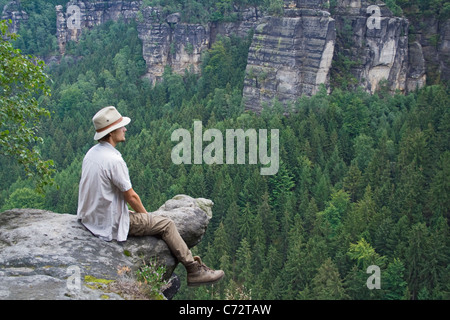 Mann sitzt auf Fels suchen ab in die Ferne, Elbsandsteingebirge, Sachsen, Deutschland, Europa Stockfoto