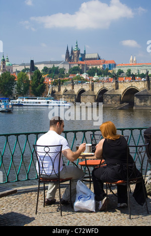 Touristen in einem Café auf der Karlsbrücke, in der Ferne Prager Burg, Prag, Tschechische Republik, Europa Stockfoto