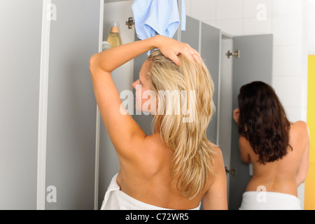 Umkleide zwei entspannte Frauen gehüllt in Handtuch laufende Dusche Stockfoto