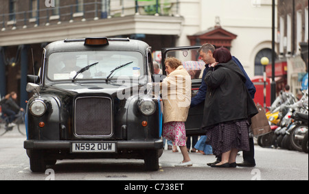 Leute steigen in ein London Taxi, Covent Garden, London. Stockfoto