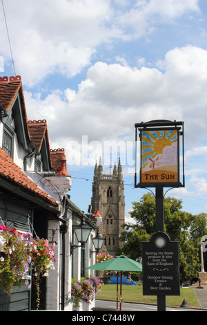 Das Zeichen der Sonne-Kneipe mit St. Thomas Becket Kirche im Hintergrund – Northaw Dorf, Hertfordshire im Sommer. Stockfoto