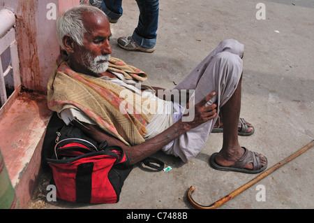 Müde Wallfahrt Mann ruhen in Har-Ki-Pairi Ghat am Ganges-Fluss. Stockfoto