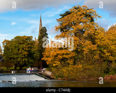 Der Fluss Avon in Stratford-upon-Avon Warwickshire England UK im Herbst mit Holy Trinity Church Turm sichtbar hinter den Bäumen Stockfoto