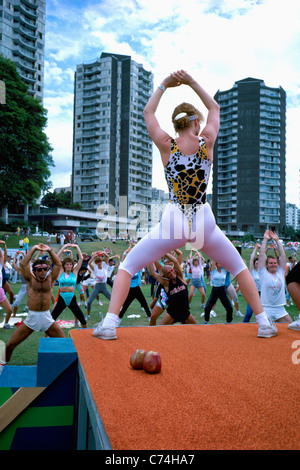 Frau im Freien trainieren und führt eine Gruppe von Erwachsenen in Outdoor-Übung, West End, Vancouver, Britisch-Kolumbien, Kanada Stockfoto