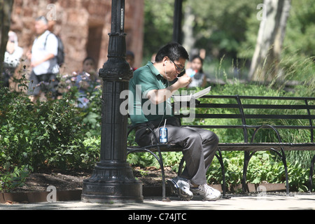 Asiatischen Mann isst Take-out im park Stockfoto