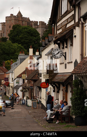 Menschen saßen draußen Dunster Memorial Hall von Dorf Post in High Street, Dunster, Exmoor National Park, Somerset, Großbritannien. Stockfoto