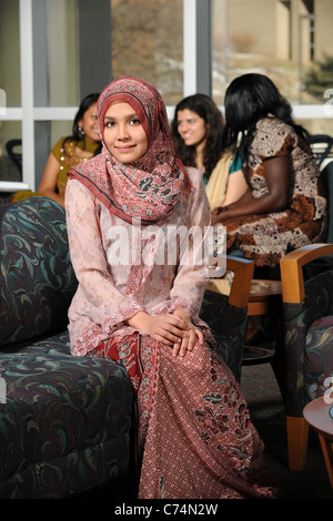 Portrait von junge muslimische Frau in traditioneller Kleidung mit anderen im Hintergrund Stockfoto