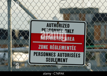 Zweisprachiges Warnschild angebracht ein Maschendrahtzaun Eintrag in Kanadas zwei Amtssprachen, Englisch und Französisch zu beschränken. Stockfoto