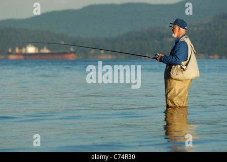 Freizeitsport Fischer stehend in das Salzwasser des Burrard Inlet Angeln auf Lachs. Stockfoto