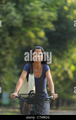 Porträt einer Frau mit dem Fahrrad in einem herbstlichen Park. Stockfoto