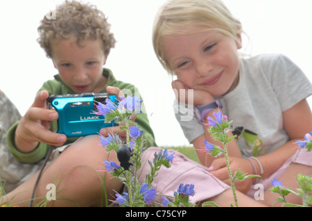 Kinder genießen Fotografieren von Bug und Tiere in einem Feld. Stockfoto