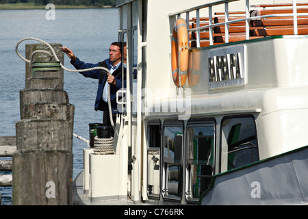 Crewman wirft ein Seil über einen Pylon von der Fähre von Chiemsee, Prien Stock Chiemgau, Upper Bavaria Germany Stockfoto