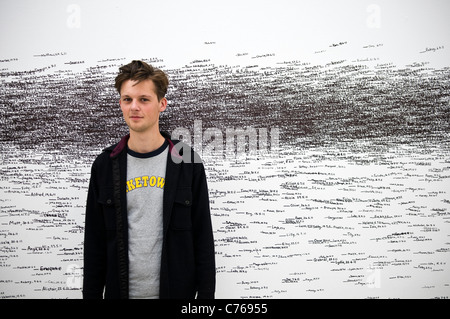 Junger Mann stand vor einer Kunstinstallation über Menschen die Höhe von Roman Ondák bei Tate St. Ives, Cornwall, UK Stockfoto