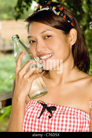 Lächelndes Mädchen mit einer Flasche Stockfoto