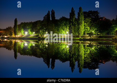 In der Nacht, ein Blick auf einen Park am Fluss gespiegelt wird. Vue de Nuit d ' un Parc Se Reflétant Dans Une Rivière. Stockfoto