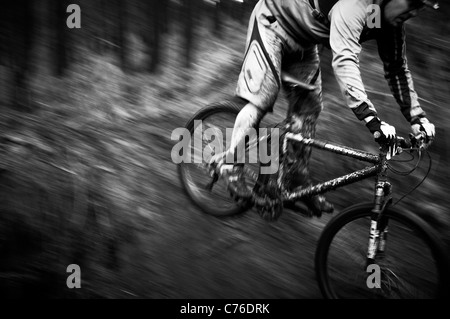 Schlamm bedeckt Mountainbike und Fahrer auf single Track schwarz / weiß Stockfoto