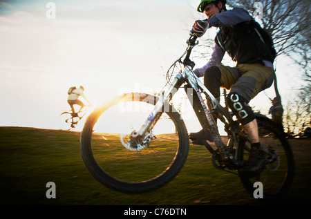 Hinterleuchtete Mountainbiker bei Sonnenuntergang Stockfoto