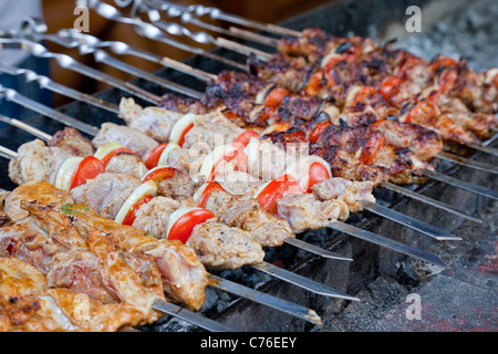 Saftige Scheiben von Fleisch mit Soße vorbereiten auf Feuer (Schaschlik) Stockfoto