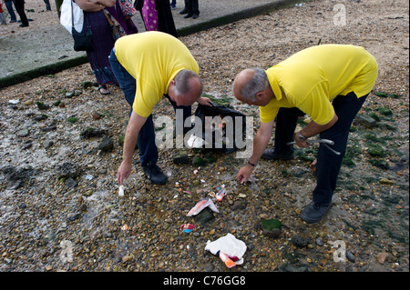 Des Rates Arbeitnehmer sammeln zerbrochene Statuetten von den hinduistischen Gott Ganesh verließ am Strand nach einem Festival in Essex. Foto: Simon Ford Stockfoto