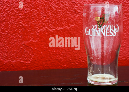 Ein leeres Guinness Glas auf einem Tisch vor einem Pub in County Cork, Irland Stockfoto