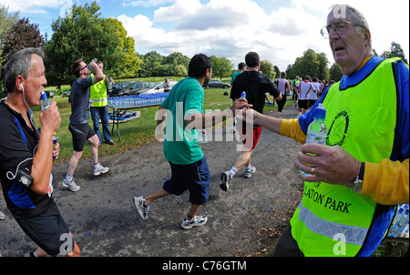 Kleine Kunststoff-Flaschen von Buxton immer noch Mineralwasser Konkurrenten in Nottingham Marathon übergeben wird. Stockfoto