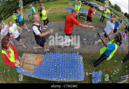 Kleine Kunststoff-Flaschen von Buxton immer noch Mineralwasser Konkurrenten in Nottingham Marathon übergeben wird. Stockfoto