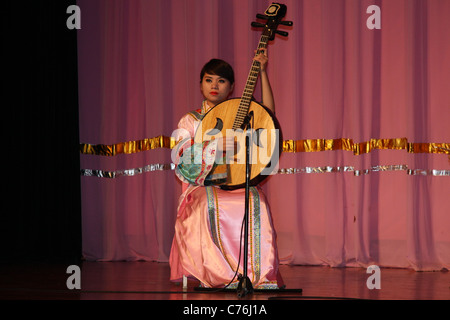 Weibliche Musiker spielt ein traditionelles Saiteninstrument bei Tang Dynastie Dinner show, Xian, China Stockfoto