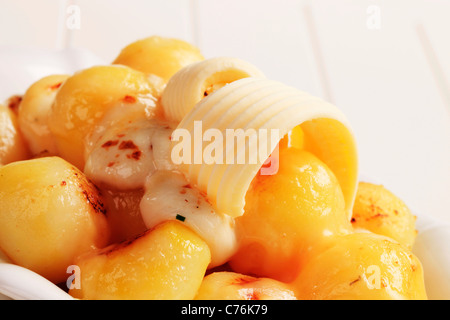 Schüssel mit Kartoffeln garniert mit geschmolzenem Käse und butter Stockfoto