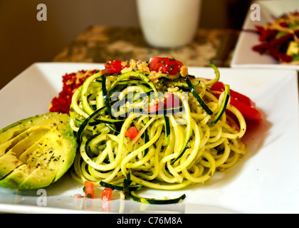 Rohe Zucchini "Pasta" garniert mit Tomatensauce. Stockfoto