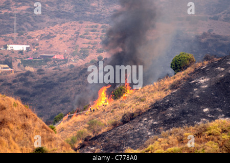 Feuerwehrleute versuchen, einen Pinsel löschen Feuer, Cabopino Golf, Costa Del Sol, Provinz Malaga, Andalusien, Spanien, Westeuropa. Stockfoto