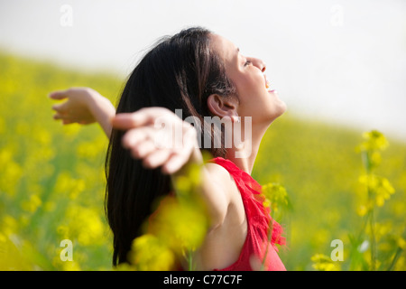 Junge Frau amüsiert sich in einem Feld Stockfoto