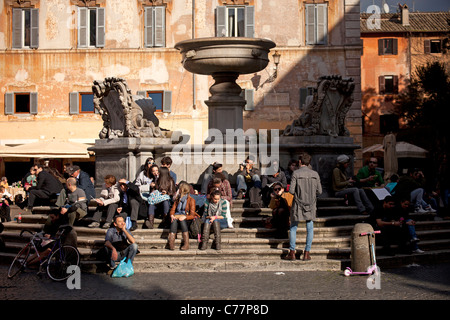 Jugend sitzt am Brunnen auf der Piazza Santa Maria in Trastevere, Rom, Italien Stockfoto